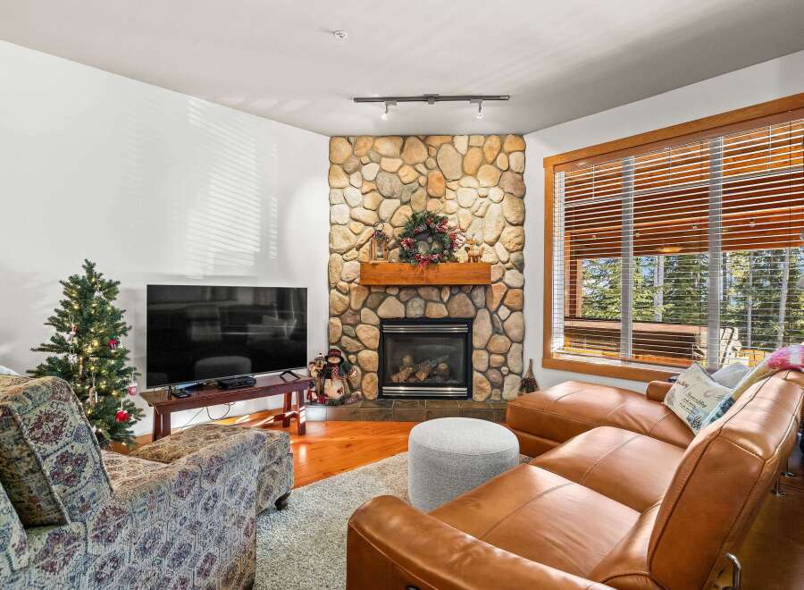 This cozy living room features a stunning stone fireplace, perfect for those chilly evenings.