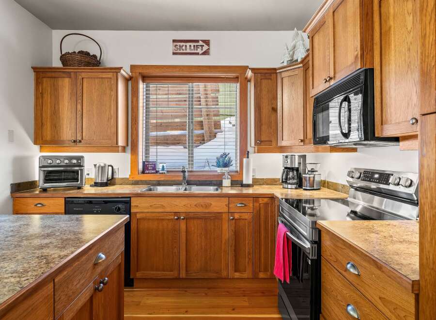 This stunning kitchen boasts beautiful wooden cabinetry and a modern appliance suite.