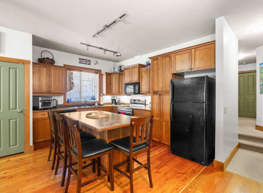This stunning kitchen boasts warm wood cabinetry and flooring, creating a cozy and inviting atmosphere.
