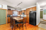 This stunning kitchen boasts warm wood cabinetry and flooring, creating a cozy and inviting atmosphere.