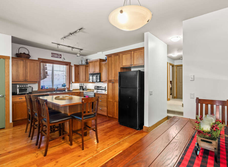 This stunning kitchen boasts beautiful wooden cabinetry and flooring, creating a warm and inviting atmosphere.