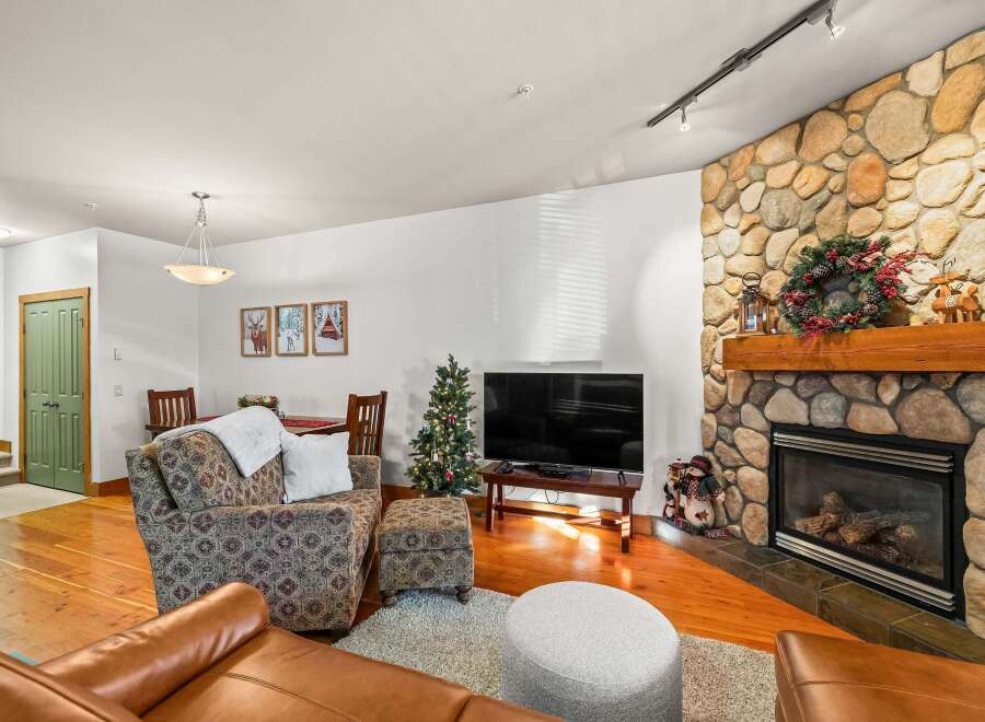 This cozy living space features a stunning stone fireplace, perfect for those chilly evenings.