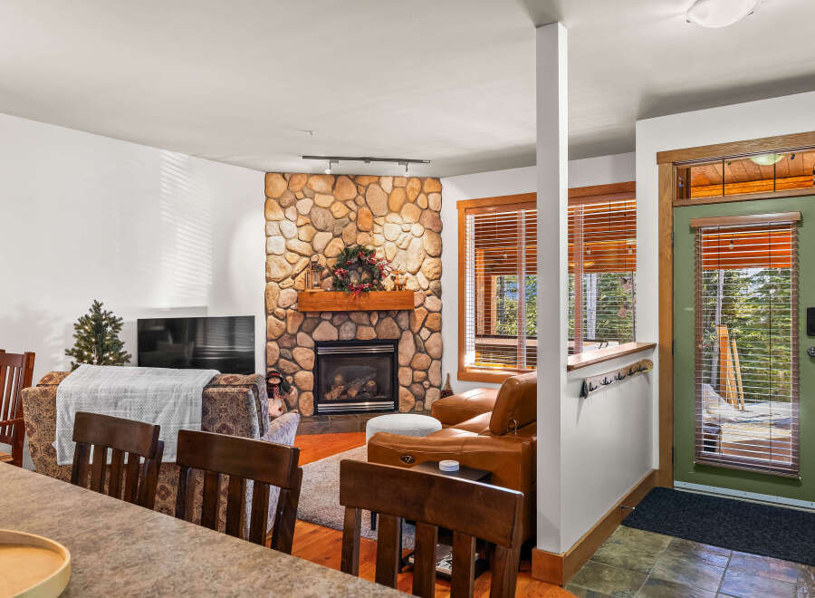 This cozy living space features a stunning stone fireplace, perfect for those chilly evenings.