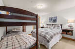 This cozy bedroom features a charming bunk bed and a comfortable queen-sized bed, perfect for accommodating guests or family.