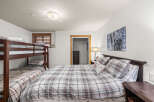 This cozy bedroom features a comfortable queen-sized bed with a plaid comforter, perfect for a relaxing night's sleep.