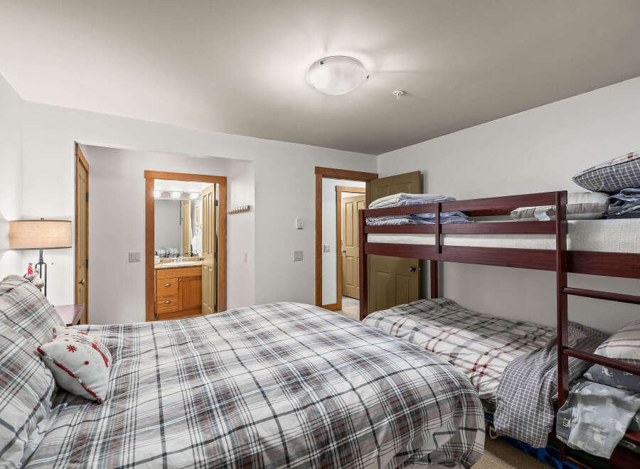 This cozy bedroom features a comfortable bed with a stylish plaid comforter and a decorative pillow.