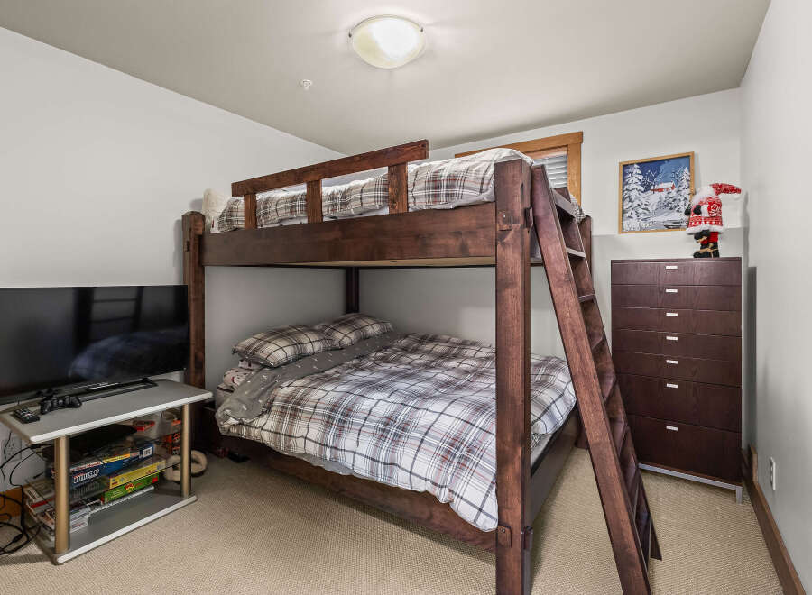 This cozy bedroom features a charming bunk bed, perfect for accommodating guests or creating a fun space for kids.