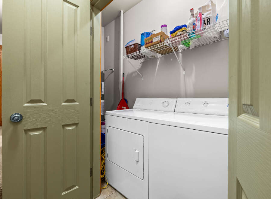 Step into the convenience of this well-organized laundry room, complete with a modern washer and dryer set.
