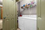 Step into the convenience of this well-organized laundry room, complete with a modern washer and dryer set.