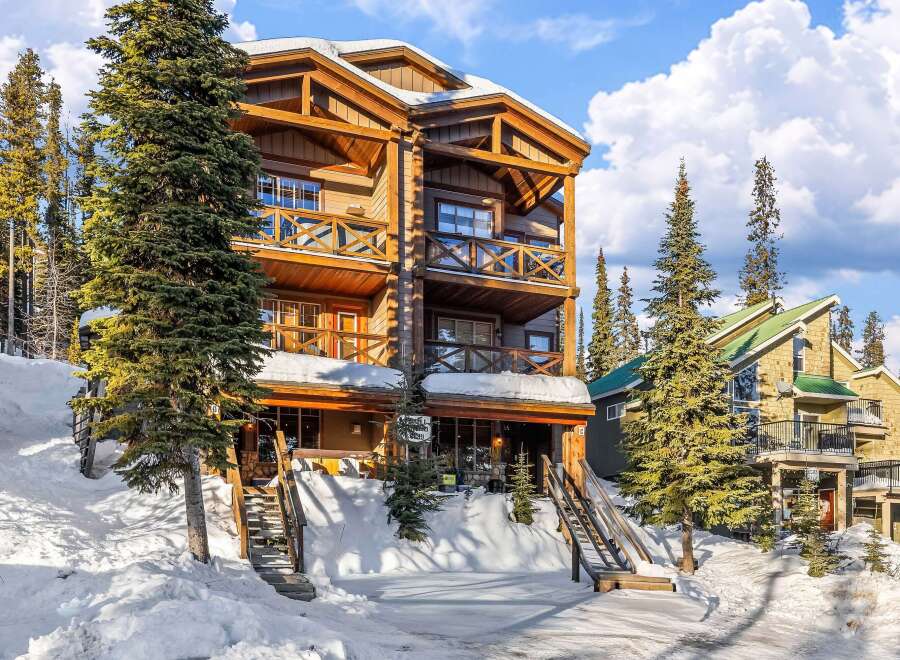 This stunning mountain lodge offers a luxurious retreat with its multi-level design and expansive balconies.