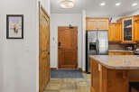 Step into this inviting entryway, featuring a beautiful wooden door and a stylish kitchen island.