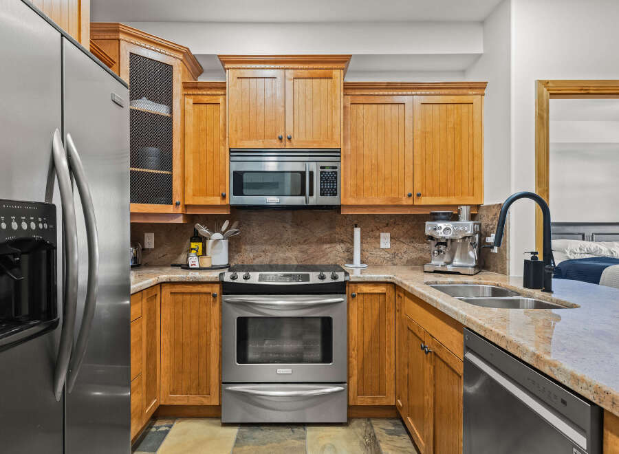 This stunning kitchen boasts beautiful wooden cabinetry, stainless steel appliances, and a sleek granite countertop.