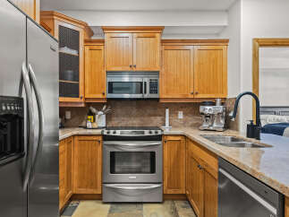 This stunning kitchen boasts beautiful wooden cabinetry, stainless steel appliances, and a sleek granite countertop.