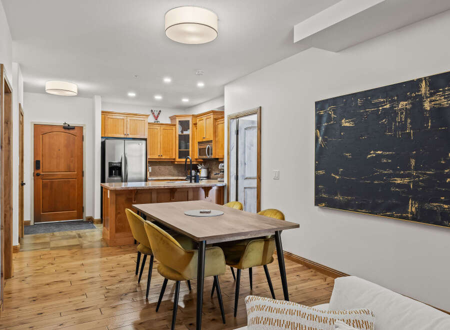 This stunning property features a modern dining area with a stylish wooden table and comfortable yellow chairs, perfect for entertaining.