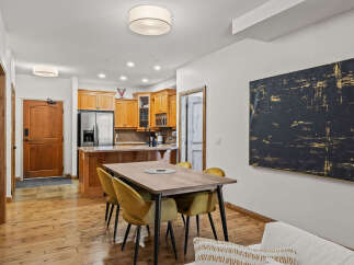 This stunning property features a modern dining area with a stylish wooden table and comfortable yellow chairs, perfect for entertaining.