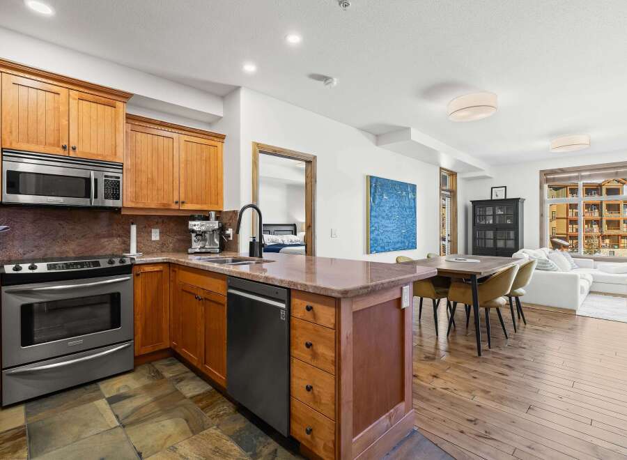 This stunning kitchen boasts custom cabinetry, stainless steel appliances, and a beautiful stone countertop.