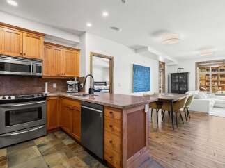 This stunning kitchen boasts custom cabinetry, stainless steel appliances, and a beautiful stone countertop.