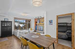 Experience luxury living in this stunning property, featuring a cozy fireplace and a modern dining area.