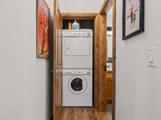 Discover the convenience of this home's dedicated laundry area, featuring a stacked washer and dryer for efficient use of space.