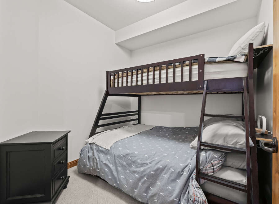 This cozy bedroom features a stylish bunk bed, perfect for maximizing space and accommodating guests.