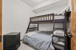 This cozy bedroom features a stylish bunk bed, perfect for maximizing space and accommodating guests.