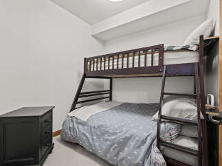This cozy bedroom features a stylish bunk bed, perfect for maximizing space and accommodating guests.