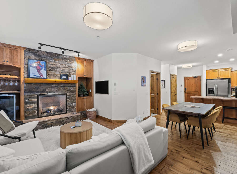 Experience the warmth of this stunning living space, featuring a cozy fireplace and elegant wooden cabinetry.