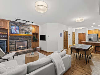 Experience the warmth of this stunning living space, featuring a cozy fireplace and elegant wooden cabinetry.