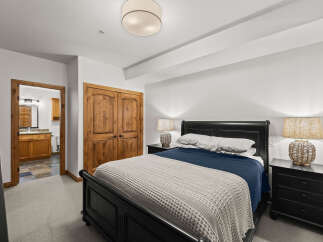 Step into this inviting bedroom, featuring a cozy bed adorned with plush bedding and a stylish throw.