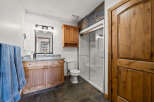 This stunning bathroom boasts a rustic charm with its wooden cabinetry and elegant stone flooring.