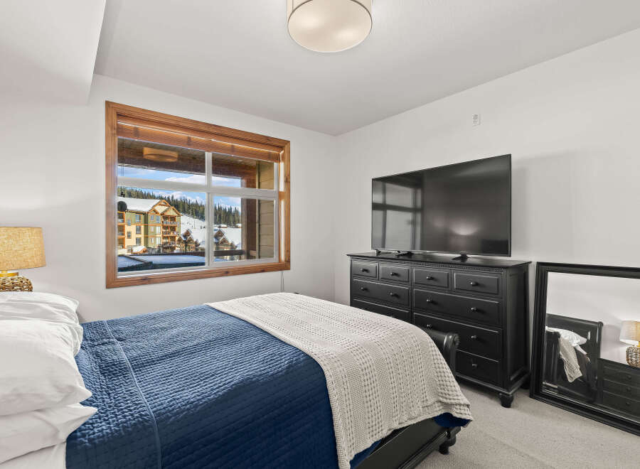 This cozy bedroom offers a serene retreat with stunning views.