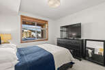 This cozy bedroom offers a serene retreat with stunning views.