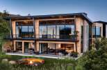 This stunning modern home boasts a sleek design with expansive windows that offer breathtaking views.