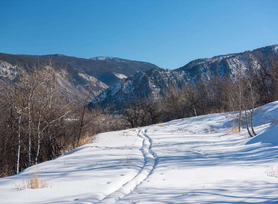 Explore the beauty of this winter wonderland! This stunning property boasts a serene landscape with fresh snow and a clear blue sky.