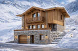Experience the epitome of alpine luxury in this stunning chalet nestled amidst a snow-covered mountain landscape.