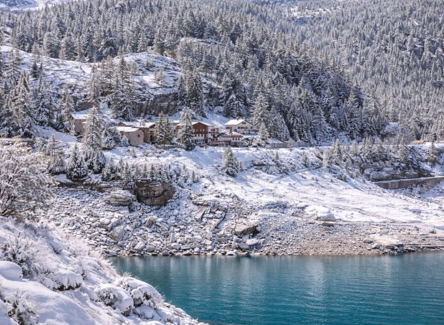 Nestled in a serene winter wonderland, this property offers breathtaking views of a snow-covered landscape and a tranquil lake.
