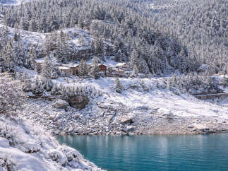 Nestled in a serene winter wonderland, this property offers breathtaking views of a snow-covered landscape and a tranquil lake.