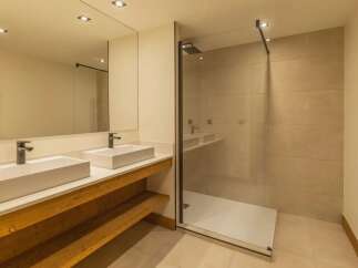 This stunning bathroom features a modern design with a spacious walk-in shower and a double vanity.