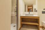 This modern bathroom features a sleek design with a spacious shower and a stylish wooden vanity.