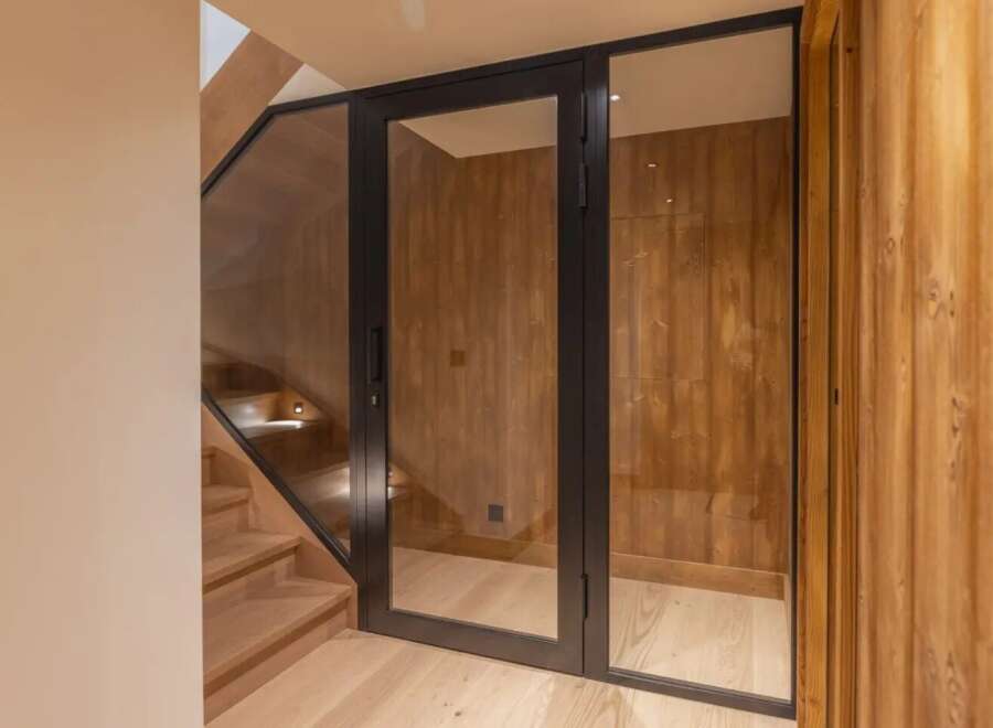 Step into luxury with this stunning property featuring a modern glass door entrance.