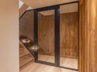 Step into luxury with this stunning property featuring a modern glass door entrance.