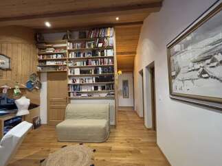 Step into this charming home with a cozy living space featuring a built-in bookcase and a comfortable sofa.
