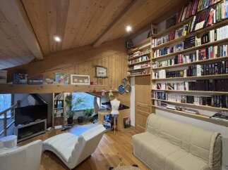 This charming property boasts a cozy living space with a unique architectural design, featuring exposed wooden beams and a loft-style layout.
