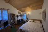 This cozy bedroom features a unique wooden ceiling and a comfortable bed, perfect for relaxation.