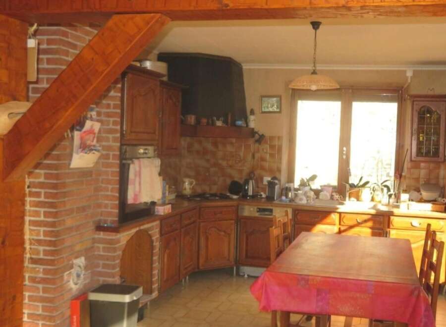 This charming kitchen boasts a rustic design with exposed wooden beams and brick accents, creating a warm and inviting atmosphere.