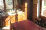 This charming kitchen features a warm, inviting atmosphere with its wooden cabinetry and a spacious dining table.