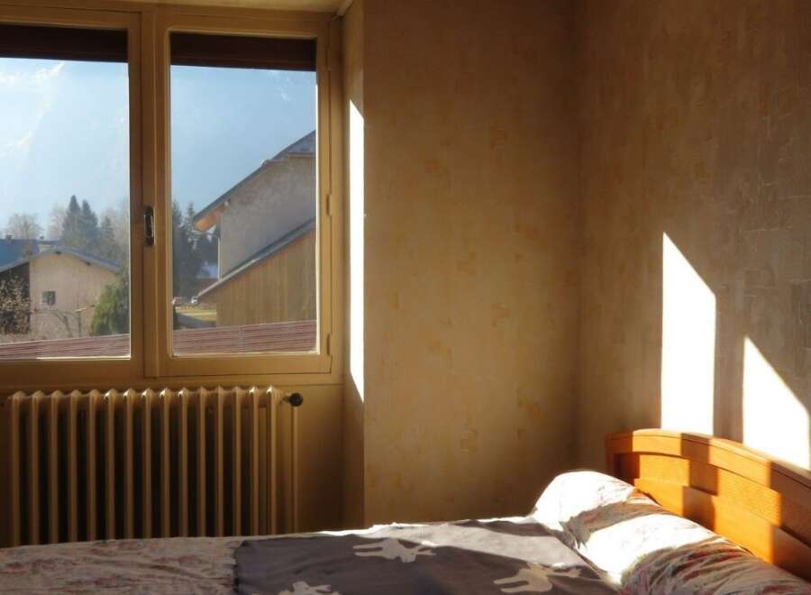 This cozy bedroom features a large window that allows natural light to flood the space, creating a warm and inviting atmosphere.