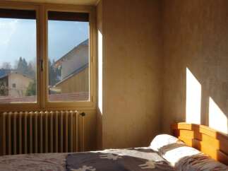 This cozy bedroom features a large window that allows natural light to flood the space, creating a warm and inviting atmosphere.