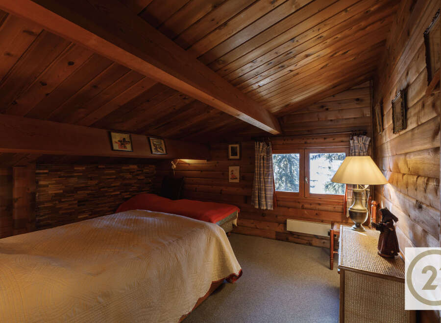 This cozy bedroom features a warm, inviting atmosphere with its wooden walls and ceiling.