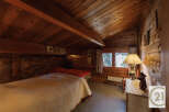 This cozy bedroom features a warm, inviting atmosphere with its wooden walls and ceiling.